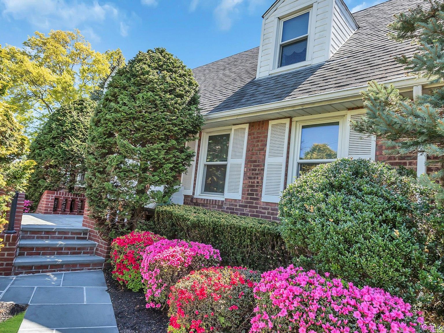 Brick facade detail with azaleas in full bloom against the front entry