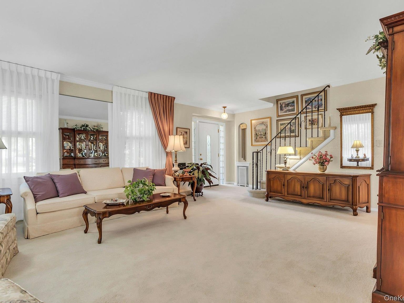 Living room with oak hardwood floors, traditional furnishings, and a view to the staircase