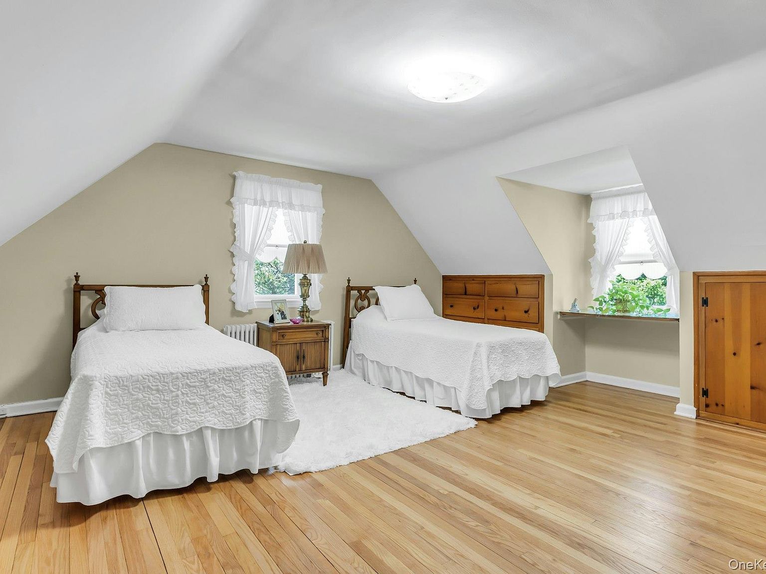 Upstairs bedroom under a vaulted Cape Cod roofline with dormer windows